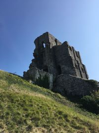 Low angle view of castle on field against clear sky