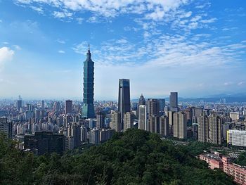 Modern buildings in city against cloudy sky