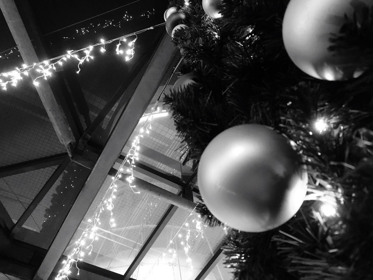 illuminated, night, low angle view, lighting equipment, ceiling, architecture, built structure, indoors, hanging, decoration, electric light, sphere, electricity, chandelier, circle, modern, celebration, light - natural phenomenon, light bulb, glowing