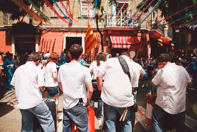Rear view of men performing at festa major de gracia in city