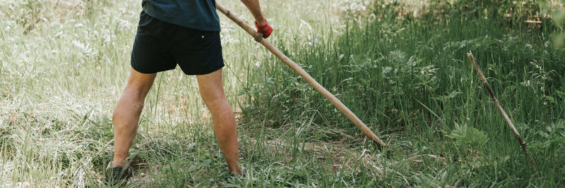 Low section of man standing on grassy field