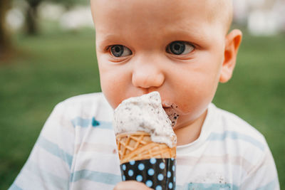 White baby with blue eyes eating ice cream with dirty mouth