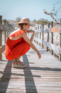 Woman crouching on footbridge