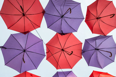 Low angle view of umbrellas hanging against sky