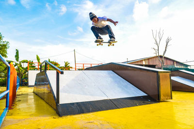 Low angle view of man skateboarding against sky