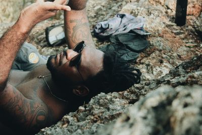 Low section of man sitting on rock