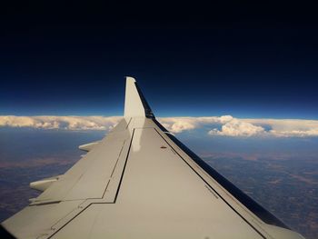 Airplane wing against blue sky