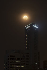 Low angle view of illuminated buildings against sky at night