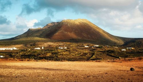 Arid landscape scenery, small village under volcano at lanzerote, canary islands