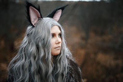 Close-up of young woman wearing costume standing against trees