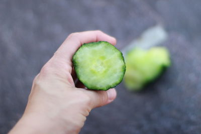 Cropped hand of person holding cucumber