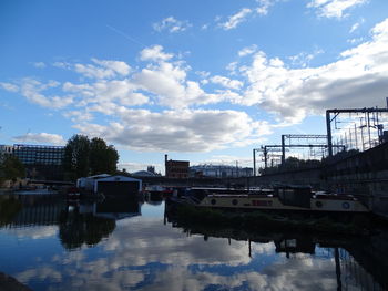Bridge over river in city against sky