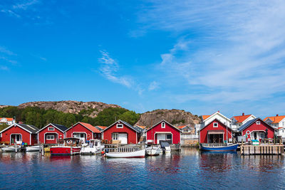 Houses by lake against blue sky