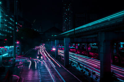 Light trails on road by bridge at night