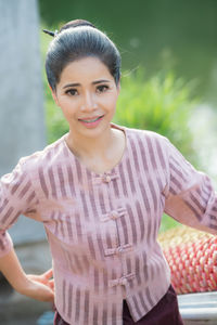 Portrait of smiling woman standing by railing on staircase