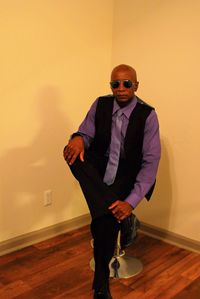 Portrait of young man wearing sunglasses standing against wall