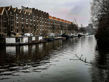 Canal amidst buildings against sky