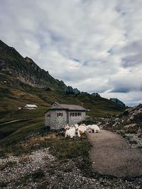 Scenic view of building by mountain against sky