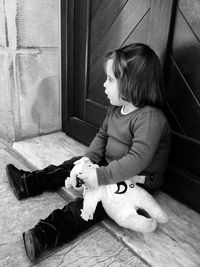 High angle view of girl with stuffed toy on floor at home