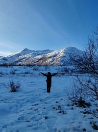 Rear view of man walking on snow covered mountain