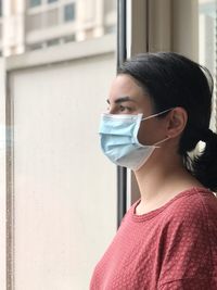 Close-up of young woman with mask looking away