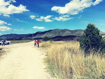 People walking on mountain against sky