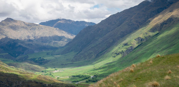 Scenic view of valley and mountains against sky