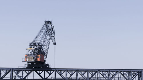 Low angle view of crane against clear sky