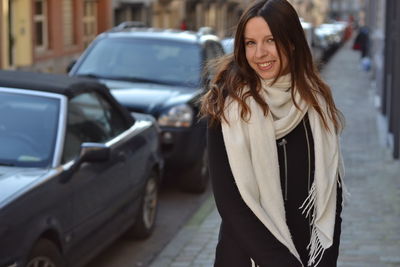 Portrait of smiling young woman standing in car