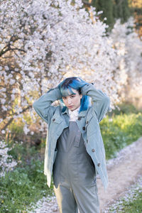 Young woman standing against plants