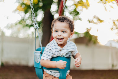 Diverse mixed race toddler boy at playground park having fun making childhood memories