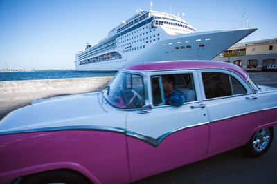 Car in sea against blue sky