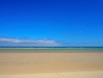 Scenic view of beach against blue sky