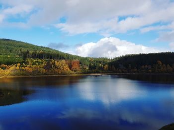 Scenic view of lake by trees against sky