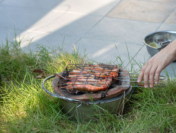 Person preparing food on barbecue grill