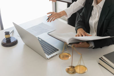 Midsection of business colleagues working on table