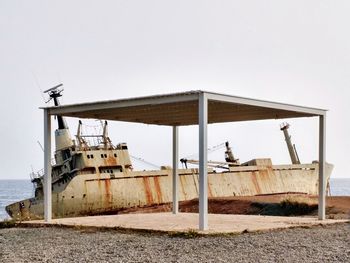 Abandoned boat at beach against clear sky