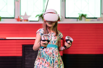 Vr game virtual reality. kid girl gamer playing on futuristic simulation video game in 3d glasses