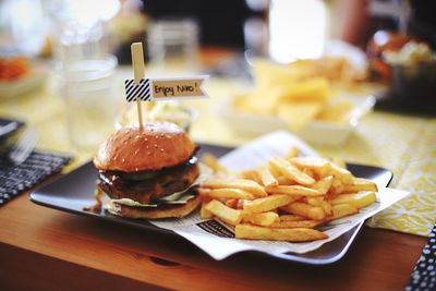 High angle view of french fries and hamburger served on table