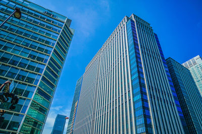 Low angle view of modern buildings against blue sky