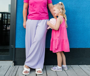 Low section of woman standing on footpath