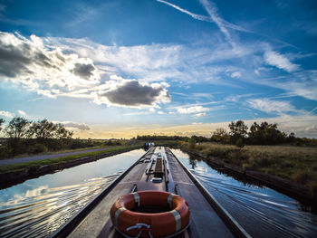 Barge on canal against sky