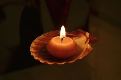 Close-up of lit candle in room