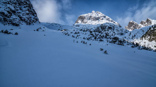 Scenic view of snowcapped mountains against blue sky