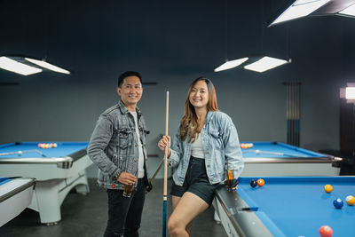 Portrait of smiling woman playing pool