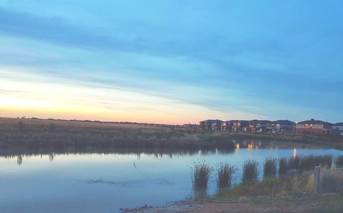 Scenic view of lake against sky at sunset