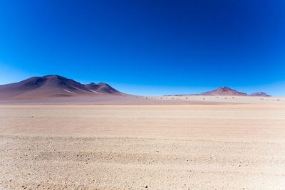 Scenic view of desert against clear blue sky