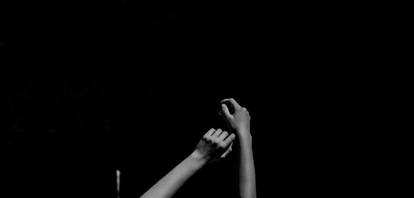 Close-up of person hand against black background