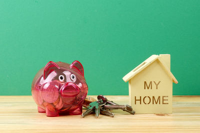 Close-up of piggy bank and keys on table