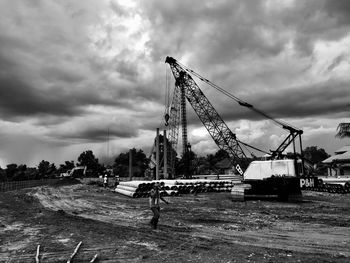 Cranes at construction site against sky